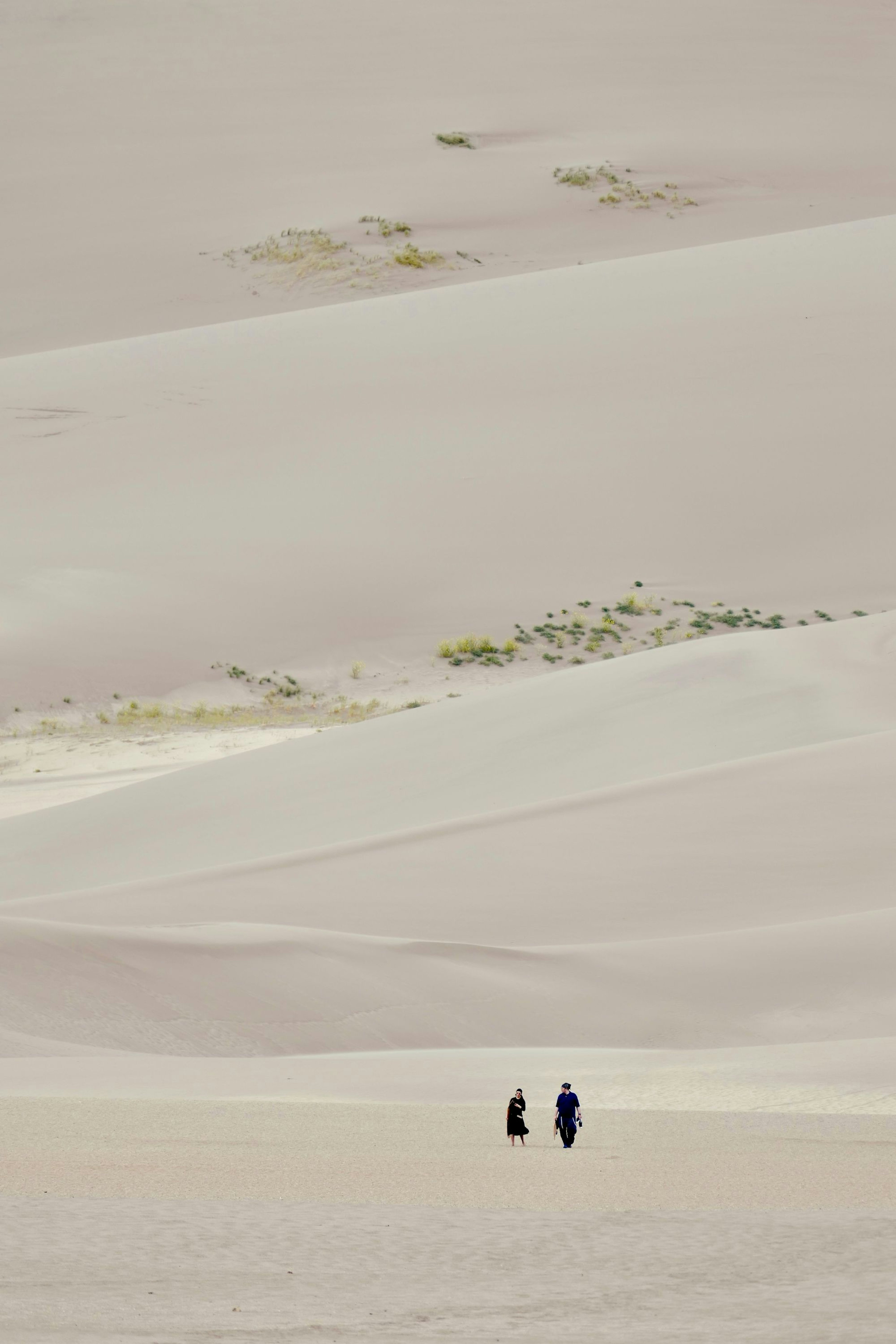 Sand dunes with 2 people far in the distance